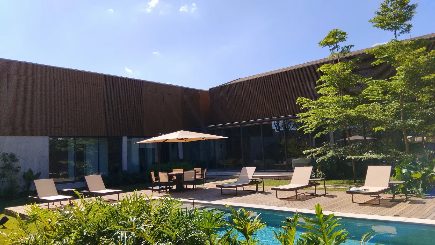 Ambiente externo do acervo Soft Garden com piscina, deck e espreguiçadeiras